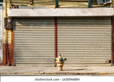 Shop Exterior With Closed Shutters, Street Facing Store, Sidewalk And Hydrant