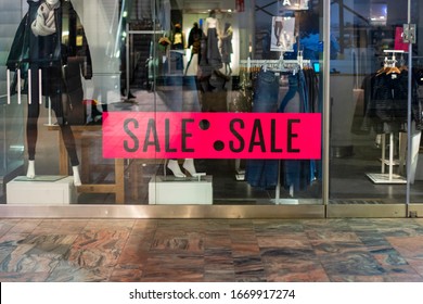 A Shop Front Display. Sale Advertisement At A Clothing Store. Pink Poster Sign With The Word Sale At The Entrance. Shop Window On The Outside Of Fashion Store Display Poster Sticker.