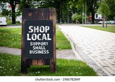 Shop Local. Support small business. Wooden billboard on the street, sunny day. - Shutterstock ID 1986782849