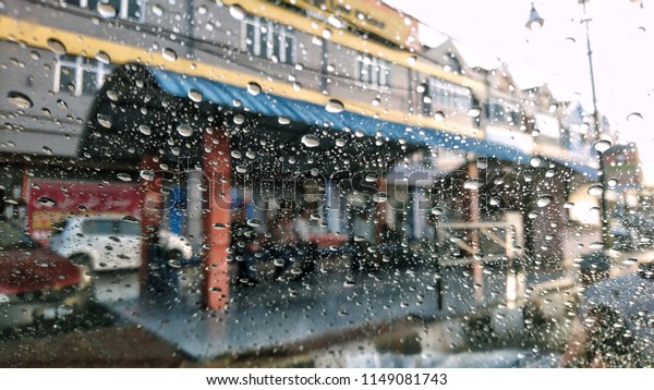 shop\
lots through windshield of the car with raindrops.\

