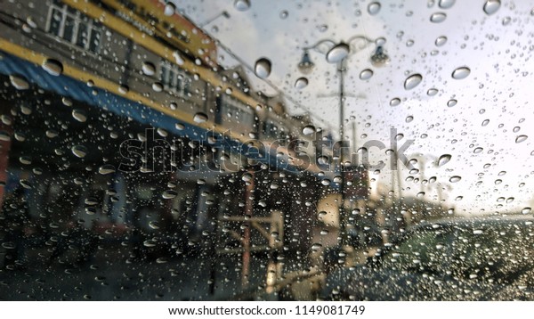shop\
lots through windshield of the car with raindrops.\
