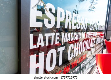 A shop window of a street café is covered with letters representing different café specialities and containing red and white letters.
