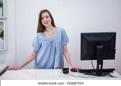 Shop Worker Standing By The Till In Fashion Boutique