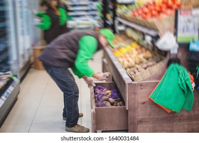 Shop Workers In Grocery Store Supermarket Stocking The Goods On The Shelves