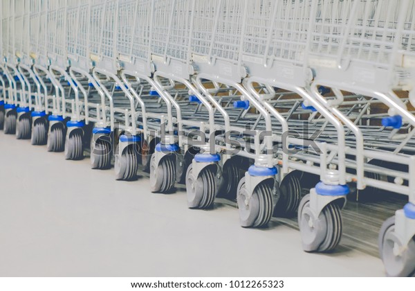 shoping cart line up in front of the shop,
close up wheel of t he cart, super
market