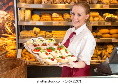 Shopkeeper in bakery or baker's shop presenting tablet with sandwiches, cold cut, cheese, cold meat and egg.  - Powered by Shutterstock