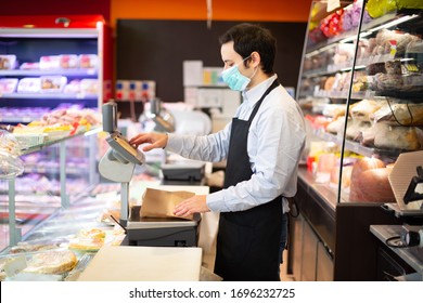 Shopkeeper running his business while wearing a mask, coronavirus pandemic concept