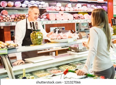 Shopkeeper serving a customer in a grocery store - Powered by Shutterstock