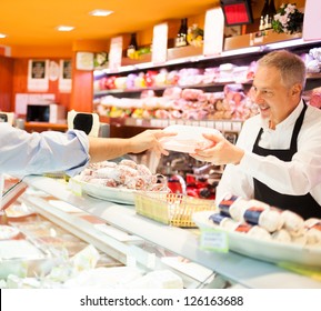 Shopkeeper Serving A Customer In A Grocery Store