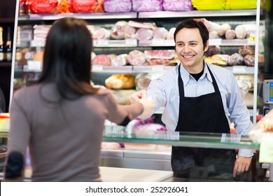 Shopkeeper Serving A Customer In A Grocery Store 