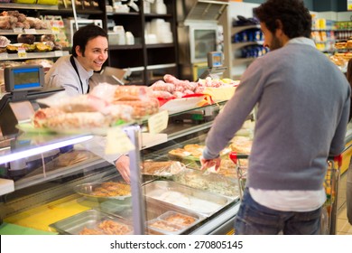 Shopkeeper Serving A Customer In A Grocery Store