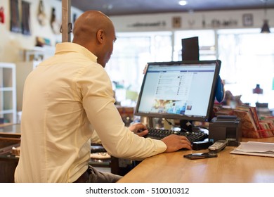 Shopkeeper Using Computer In Vintage Shop