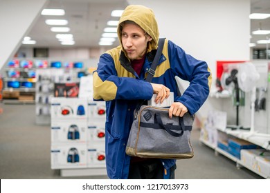 shoplifter in the electronic store supermarket stealing new gadget