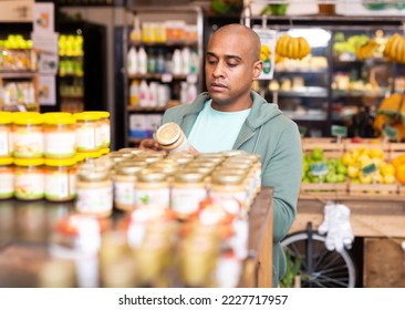 Shopper reads description of canned food at a grocery supermarket - Shutterstock ID 2227717957