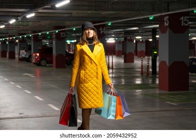 Shopper woman with purchases walking on the parking lot of shopping center. - Shutterstock ID 2059432952