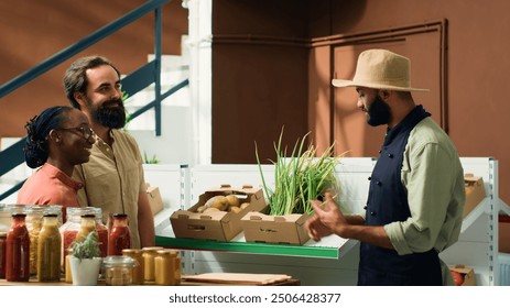 Shoppers at nearby zero waste green shop enquiring about organic cultivation and fresh vegetables kept in crates. Grocery store staff suggesting nutritious food selections to vegan couple. - Powered by Shutterstock