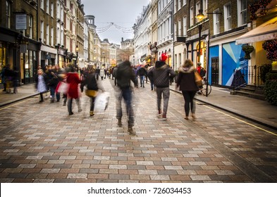 Shoppers Walking Down Busy Retail High Street In London. Motion Blurred 