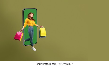 Shopping App. Happy Shopaholic Lady Jumping From Big Phone Screen Holding Colorful Shopper Bags On Green Studio Background. E-Commerce, Great Sales And Mobile Offers. Panorama, Free Space