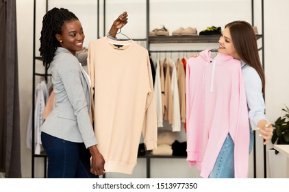 Shopping Assistance. Cheerful Personal Fashion Stylist Choosing Seasonal Updates For Female Client In Showroom.