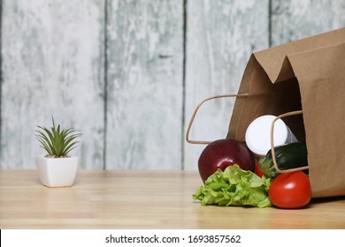 shopping bag with groceries.  Recycled paper shopping bag  with vegetables .on a wooden background. Eco product. Vegetables. Salad