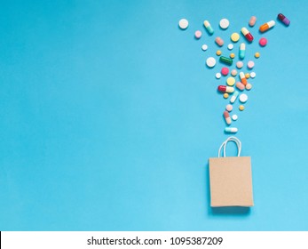 Shopping Bag W/ Assorted Medicine Pills On Light Blue Background. Creative Idea For Dietary Supplements And Consumer Behavior In Health Marketplace Concept. Flat Layout. Copy Space.