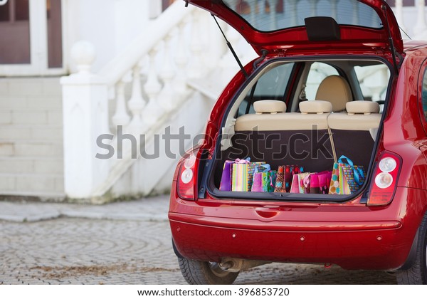 Shopping Bags in Car trunk. Open the trunk of the\
car with bags of purchases. Autumn sales, shopping. Open the trunk\
with shopping bags