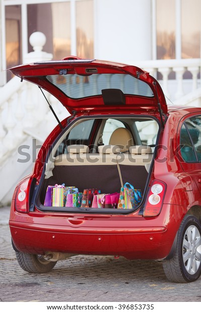 Shopping Bags in Car trunk. Open the trunk of the\
car with bags of purchases. Autumn sales, shopping. Open the trunk\
with shopping bags