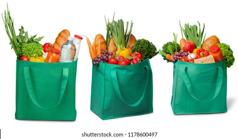 Shopping bags with groceries on white