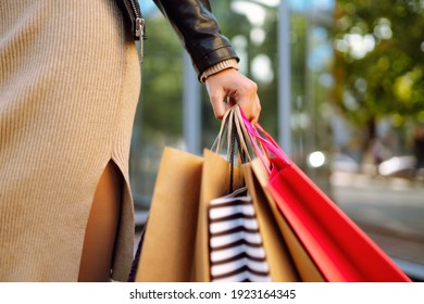 Shopping bags in the woman hands. Young woman after shopping on the city street. The joy of consumption, Purchases, black friday, discounts, sale concept. - Powered by Shutterstock