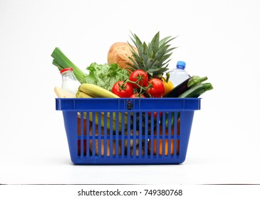 Shopping basket full of vegetables, fruits, bread and milk products on white background.