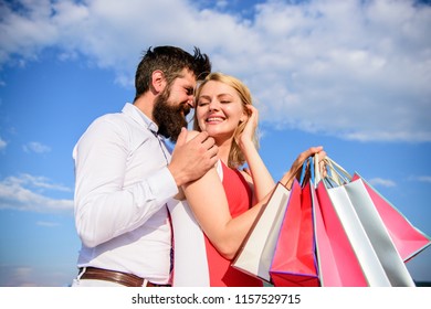 Shopping Brings Positive Emotions. Couple With Luxury Bags Hugs Blue Sky Background. Happy Couple Luxury Purchases. Man Beard And Girl Enjoy Shopping Together. Family Bought Excellent Clothes.