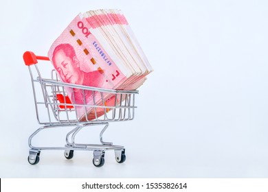 Shopping Cart With 100 Yuan Chinese Money Inside On White Background. Concept Of Money And Economy Of The Consumer.