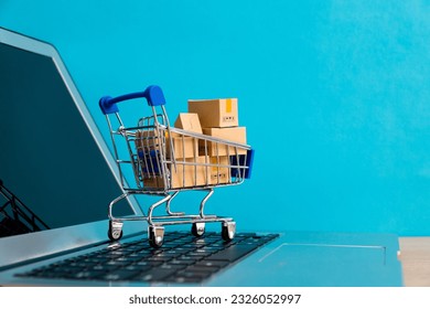 Shopping cart with boxes on laptop keyboard. - Powered by Shutterstock