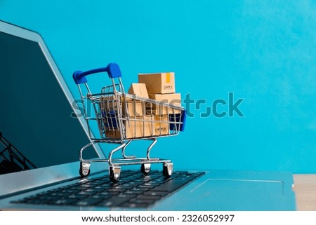 Shopping cart with boxes on laptop keyboard.