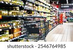 A shopping cart by a store shelf in a supermarket