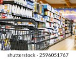 A shopping cart by a store shelf in a supermarket