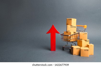 Shopping Cart With Cardboard Boxes And Red Up Arrow. Growth Wholesale And Retail. Improving Consumer Sentiment, Economic Growth. Rising Prices For Goods, Inflation. Growth Of Popularity Of The Product