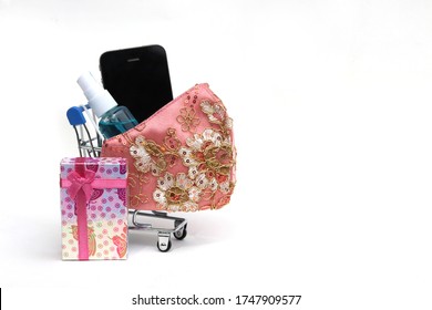  Shopping Cart With Cloth Face Mask ,hand Sanitizer Spray,gift And Smart Phone On White Wall Background.Concept For New Normal,new Lifestyle And Shopping Online After Covid-19 Coronavirus Pandemic.