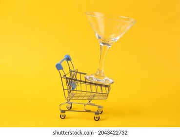 Shopping Cart With Cocktail Glass On Yellow Background