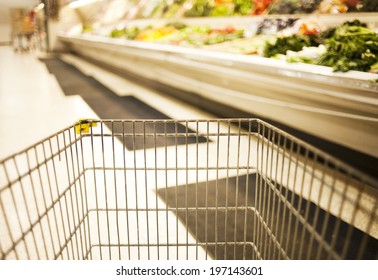 A Shopping Cart In Front Of The Produce Section.