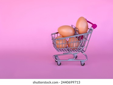 shopping cart full of eggs on a pink background, happy easter greeting card