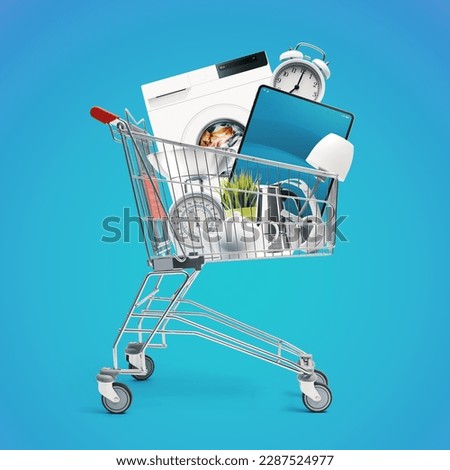 Shopping cart full of household goods, appliances and electronics: sales and retail concept