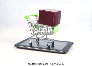 Shopping cart or metal trolley on mobile tablet for Online shopping and ecommerce.