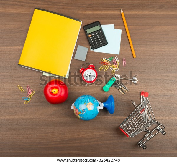 Shopping cart\
with office supplies on wooden\
table
