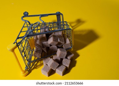 a shopping cart from a supermarket is visible on a yellow background. small cart abstract background texture background of a billboard or poster day