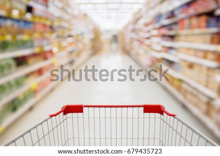 Shopping cart view in Supermarket aisle with product shelves abstract blur defocused background
