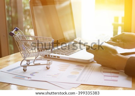 Shopping Cart and woman holding credit card and smart phone with laptop for a concept shopping online.