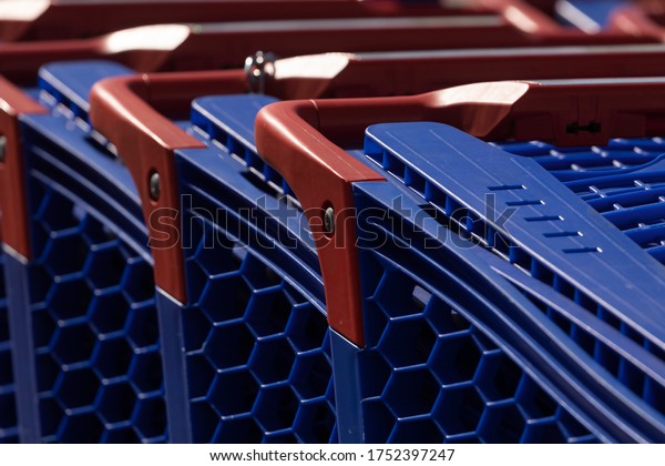 Shopping carts, blue in color\
and made of plastic, stored in the outdoor car park of a large\
shopping center, in the Ciudad de la Imagen district, Madrid,\
Spain.