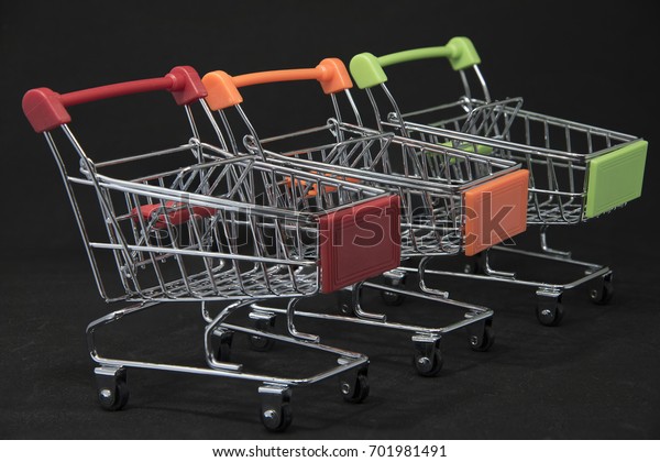Shopping Carts red, orange, green on a black\
background.Shopping\
Concept.
