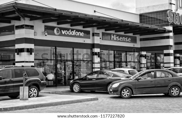Shopping\
center and cars. Vodafone office. Vehicles in a parking lot. World\
brands. Hisense store. Shopping Mall. Black White Photography.\
Market in Ghana, Accra – January 20, 2017\
